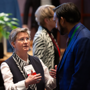 Photo of Joni Rutter talking to attendee at Rare Disease Day at NIH